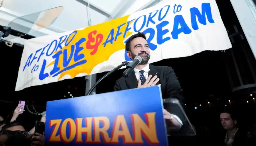 Mężczyzna przemawia na wiecu, za nim baner "AFFORD TO LIVE & AFFORD TO DREAM". Jego marzenie o lepszej przyszłości dla Nowego Jorku.