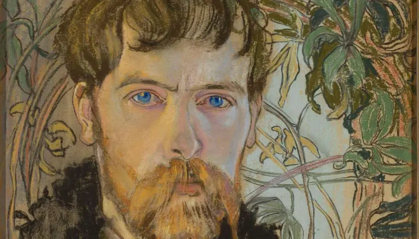 Portret mężczyzny z rudą brodą i niebieskimi oczami, w tle roślinność. Czy to przykład, jak wygląda modernizm?